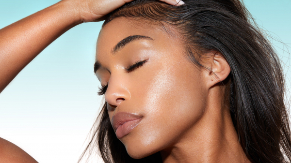 Beautiful photo of Lori Harvey with gorgeous clean skin on a sky blue background