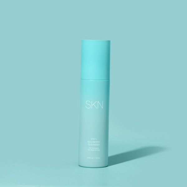 Light blue bottle of SKN by Lori Harvey Goji Berry Cleanser on a light blue background